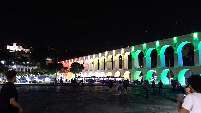 Arco da Lapa distante, a noite, com luzes o deixando colorido